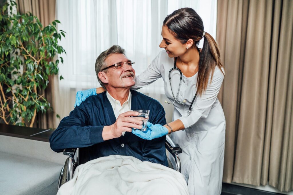 Home health physical therapist helping a patient walk safely after knee or hip replacement surgery.